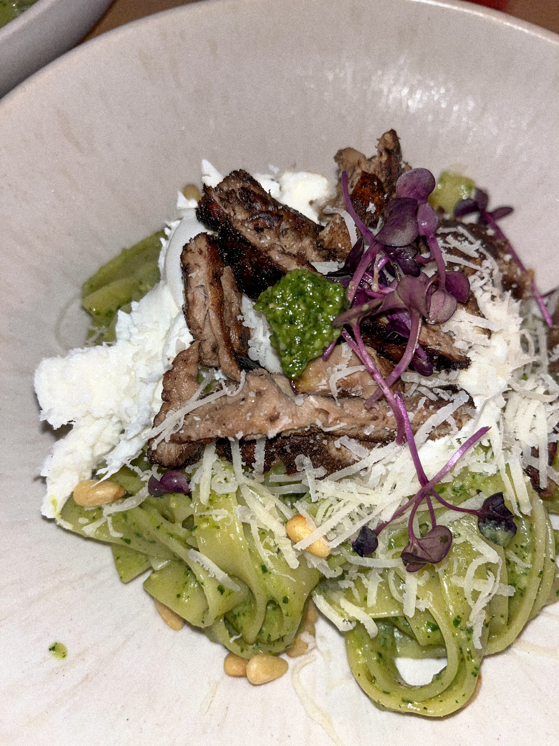 Ein leckeres gekochtes Gericht mit Nudeln, Pesto, Parmesan, Kräutern und angebratenen Steak aus Lions Mane und Igelstachelbart