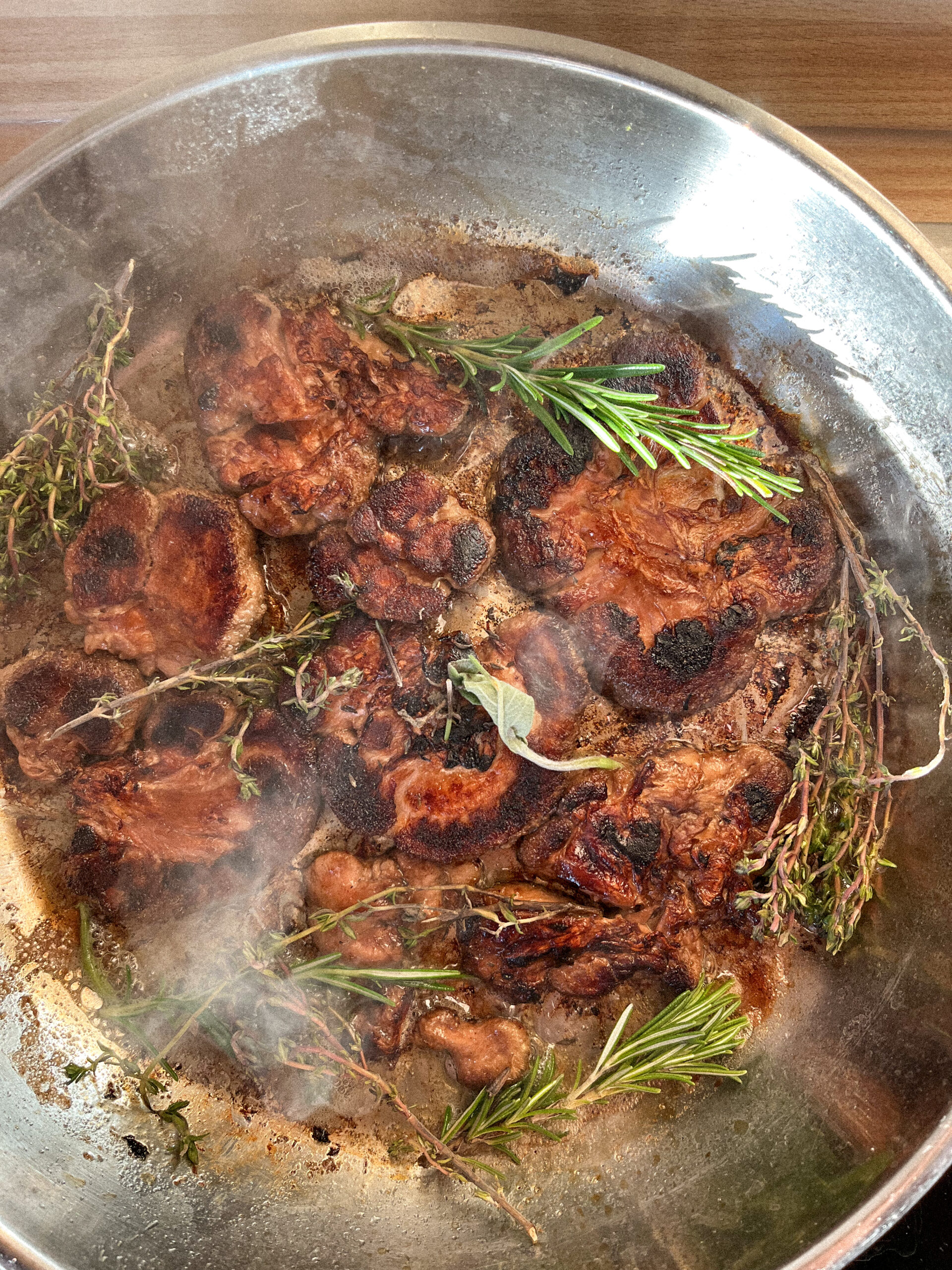Ein gekochtes Gericht von BetterMyco aus Lions Mane, Igelstachelbart in Form von Steak als leckerer Fleischersatz in einer Pfanne mit Kräutern